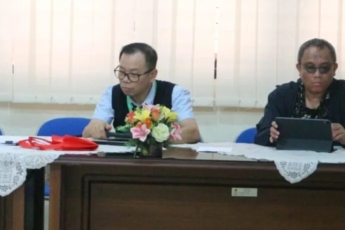 Anthon F. Susanto duduk di meja panel bersama Shidarta, membaca dari tablet